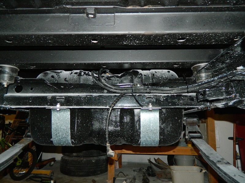 Undercarriage view of a fuel tank with metal straps