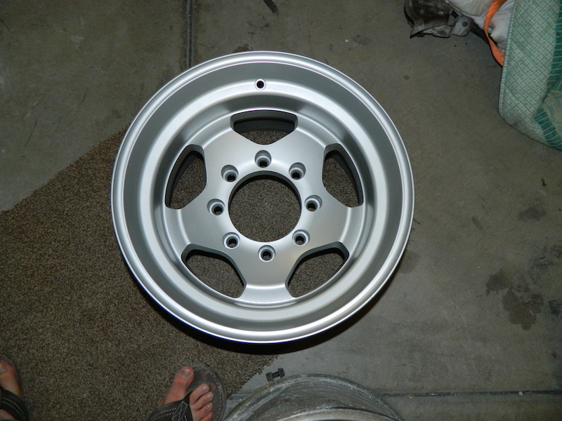 Silver aluminum wheel with five spokes and a multi-lug pattern