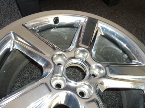 2004 Mercury Grand Marquis - A close-up view of a shiny chrome wheel, showing the five lug nut holes and the Supermotors.net watermark.