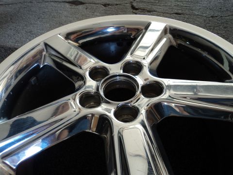 2004 Mercury Grand Marquis - A single chrome wheel is shown, reflecting its surroundings.