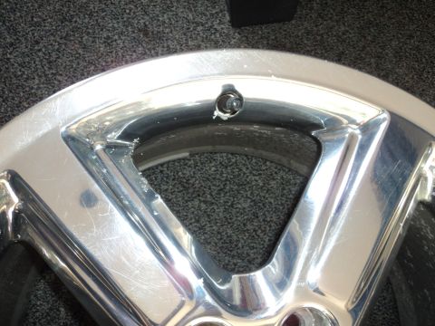 2004 Mercury Grand Marquis - Close-up of a damaged chrome alloy wheel, showing wear and tear.