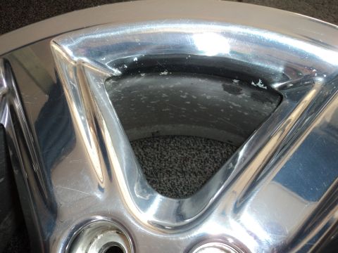 2004 Mercury Grand Marquis - A close-up of a chrome wheel shows wear and tear, with scratches and discoloration.