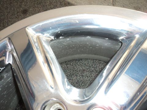 2004 Mercury Grand Marquis - Close-up of a damaged chrome wheel, showing pitting and wear.