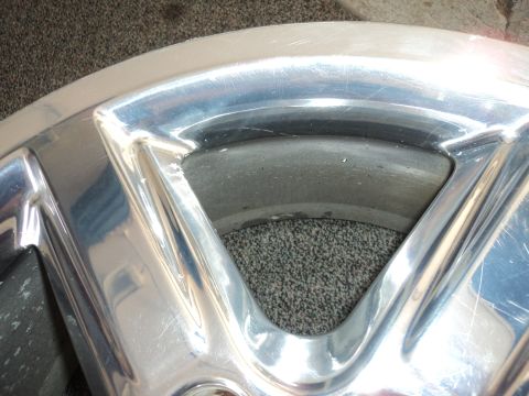 2004 Mercury Grand Marquis - Close-up view of a scratched chrome wheel rim.