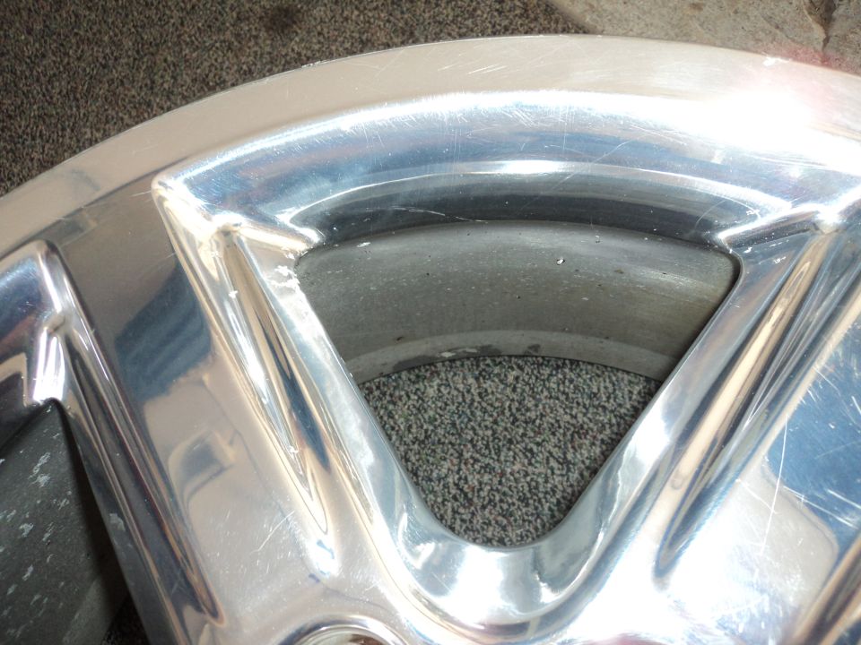 Close-up of a chrome wheel rim with visible scratches