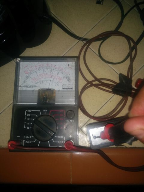 1988 Ford Bronco - An analog multimeter is shown with its probes connected to a component, indicating a diagnostic or testing process.
