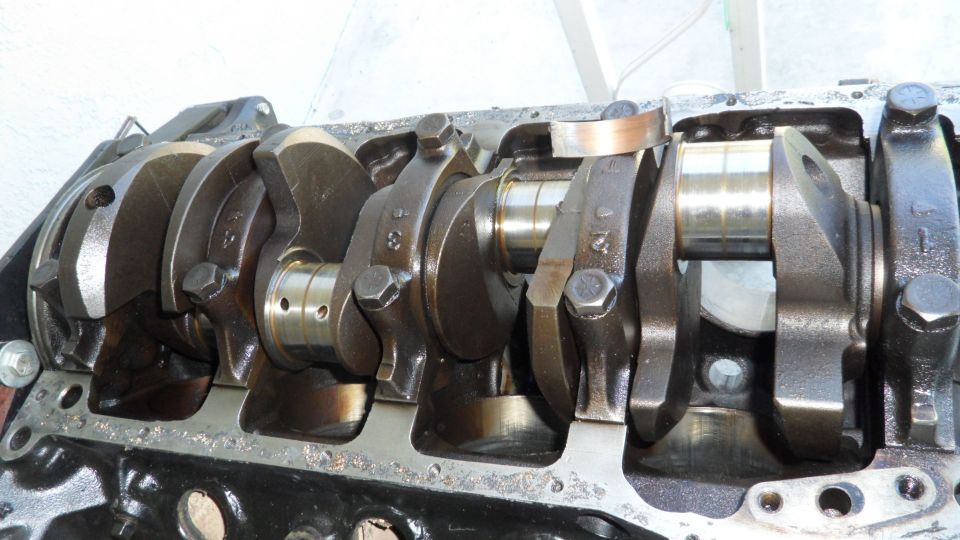 Engine crankshaft with connecting rods attached, showing bearing surfaces