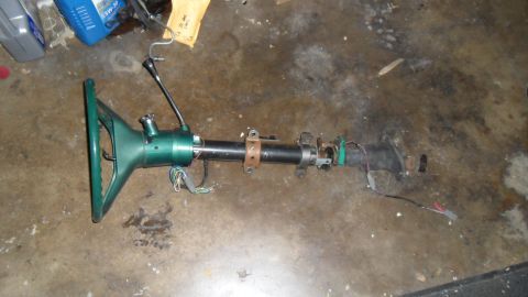 1972 Ford Ranchero - A detached steering column assembly rests on a dirty concrete floor, with various wires and components visible.