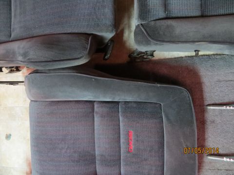 1985 Volkswagen GTI - Close-up of dark fabric car seats red "Recaro" branding on the lower cushion.
