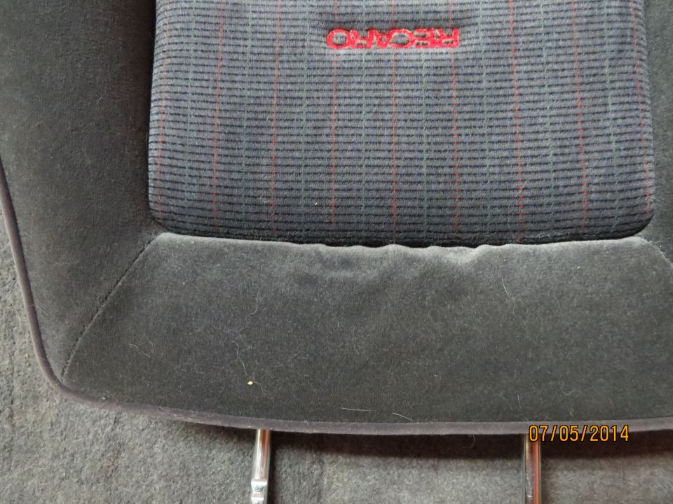 Close-up of car seat fabric showing a red RECARO logo and striped pattern