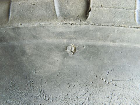 1979 Ford Bronco - A nail is lodged in the tread of a tire, indicating a potential puncture.