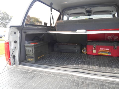 1994 Ford Bronco - Interior view of a truck bed, showing storage containers including an ammo can and a red Craftsman toolbox.