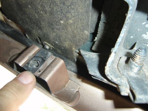 1996 Ford Bronco - Undercarriage bracket with bolt and rubber grommet, likely a mounting point.