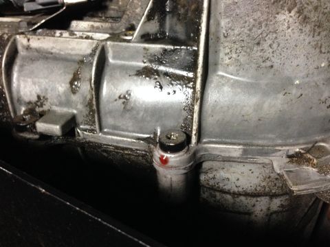 1996 Ford Bronco - A close-up view shows a transmission fluid leak from a metal component, with a screw visible near the drip.