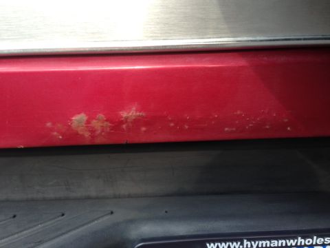 1995 Ford Bronco - Rust is visible on the lower portion of the red tailgate of a 1995 Ford Bronco.