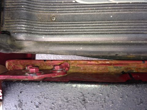 1995 Ford Bronco - Close-up of a rusted metal bracket and bolts, likely from a vehicle's undercarriage.
