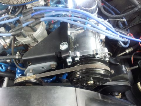 1976 Ford Ranchero - Close-up of an engine bay, focusing on the air conditioning compressor and associated belts.