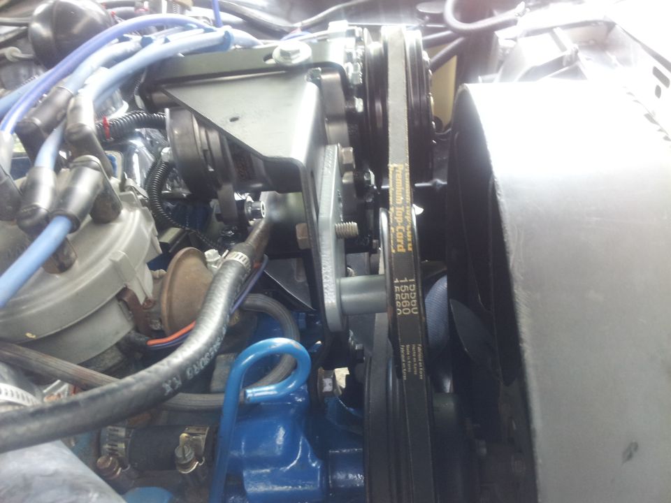 Close-up of engine belts and pulleys, showing the fan and some hoses