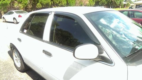2000 Mercury Grand Marquis - A white sedan is parked on a sunny day, with another vehicle visible in the background.