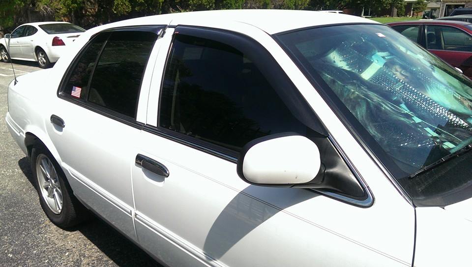White 2000 Mercury Grand Marquis sedan, side view, with tinted windows and a sunshade visible through the windshield