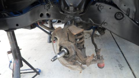1972 Ford Ranchero - The vehicle's front suspension is disassembled and supported by jack stands for maintenance.