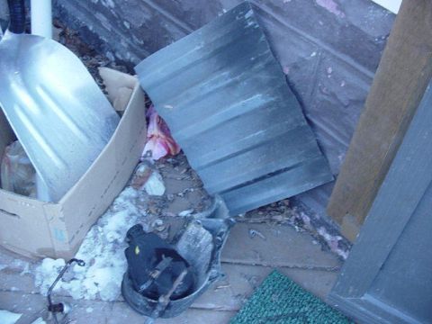 1992 Ford Bronco - A collection of assorted items, including a shovel and a car part, are piled up outdoors.