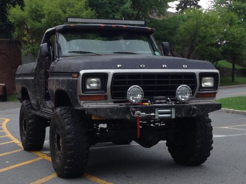 1979 Ford Bronco - Modified black 1978 Ford Bronco with off-road features is parked on asphalt.