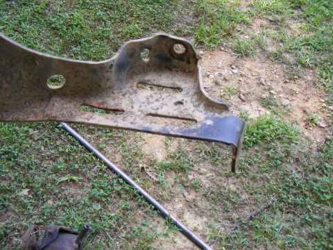 Rusted metal bracket with oblong holes and mounting points
