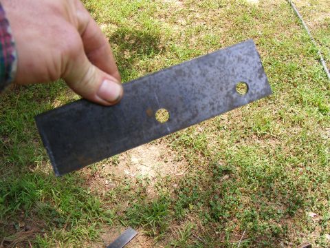 Metal bracket with two holes held by a hand