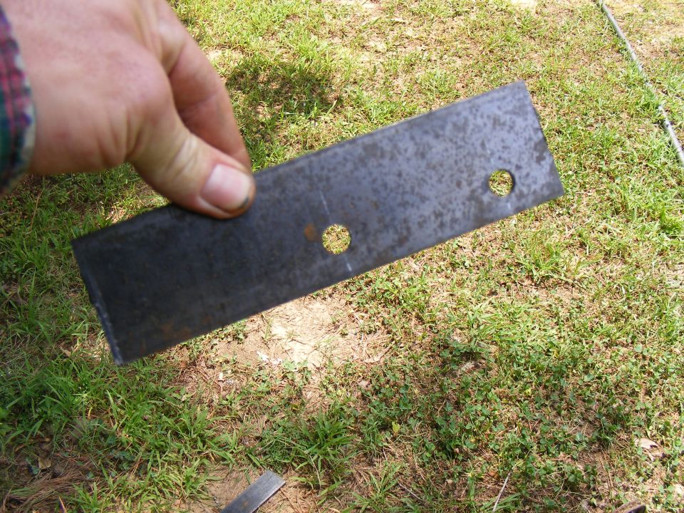Metal bracket with two holes held by a hand