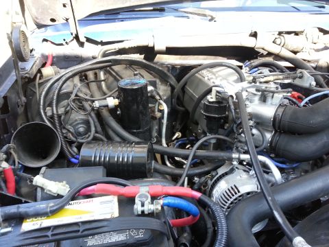 1994 Ford Bronco - Close-up view of an engine bay, focusing on the battery and engine components.
