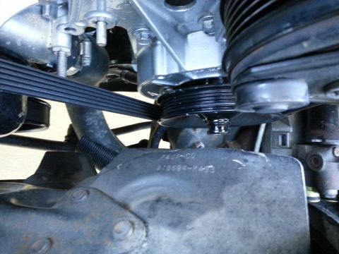 1994 Ford Bronco - Close-up view of engine components, including belts and pulleys, with visible part numbers.