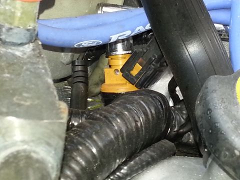 1994 Ford Bronco - A close-up view of a vehicle's engine compartment, focusing on a fuel injector and associated hoses.