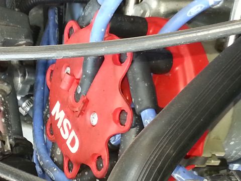1994 Ford Bronco - Close-up of an engine's red MSD distributor cap with blue spark plug wires.