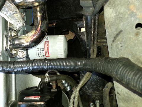 1994 Ford Bronco - Close-up view of a Motorcraft FL-1A oil filter and exhaust manifold components.