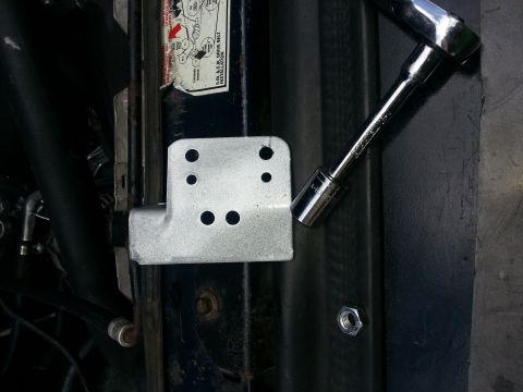 1994 Ford Bronco - Close-up of a metal bracket and socket wrench in an engine bay.