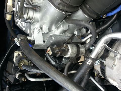 1994 Ford Bronco - Close-up view of engine parts, including a throttle body and various hoses.