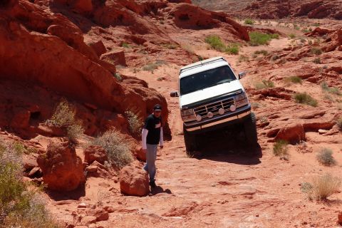 1995 Ford Bronco - 1995 Ford Bronco tackling a challenging off-road course in a desert landscape.
