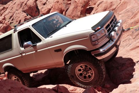 1995 Ford Bronco - A white Ford Bronco navigates a rocky off-road trail.