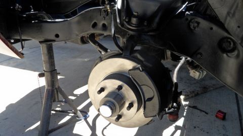 1972 Ford Ranchero - Close-up of a vehicle's suspension and braking system, supported by jack stands.