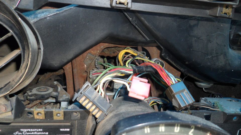 Vehicle dashboard wiring harness with blue, pink, and gray connectors, and numerous colored wires