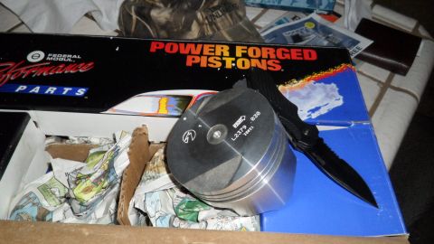 1972 Ford Ranchero - A piston sits on a box of Federal Mogul performance parts next to a folding knife.