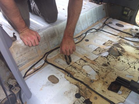 1994 Ford Bronco - Cleaning the interior floor of a vehicle, revealing exposed wiring and floor panels.