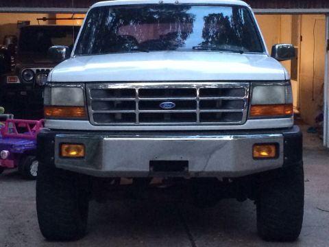 1994 Ford Bronco - Front view of a white 1994 Ford Bronco, its distinctive chrome grille and amber turn signals.