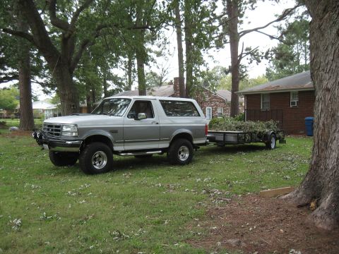 1994 Ford Bronco - 1994 Ford Bronco parked on grass, hitched to a trailer loaded with yard debris.