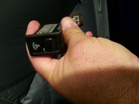 1991 Ford Festiva - A car interior switch with a knob and a symbol is held in a hand.