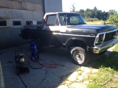 1978 Ford Bronco - This 1978 Ford Bronco is parked outside a building with two air compressors nearby.