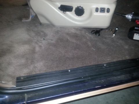 1994 Ford Bronco - Close-up of a car's interior carpet and seat controls, with tools scattered nearby.