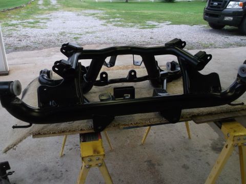 1967 Ford Mustang - Car suspension subframe assembly, painted black and resting on sawhorses.