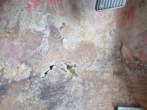 1978 Ford Bronco - The interior floor pan shows significant rust and damage, indicating a need for repair.